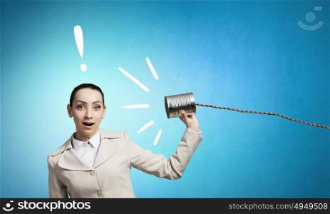 Woman with deaf phone. Young pretty businesswoman attaching tin phone to ear