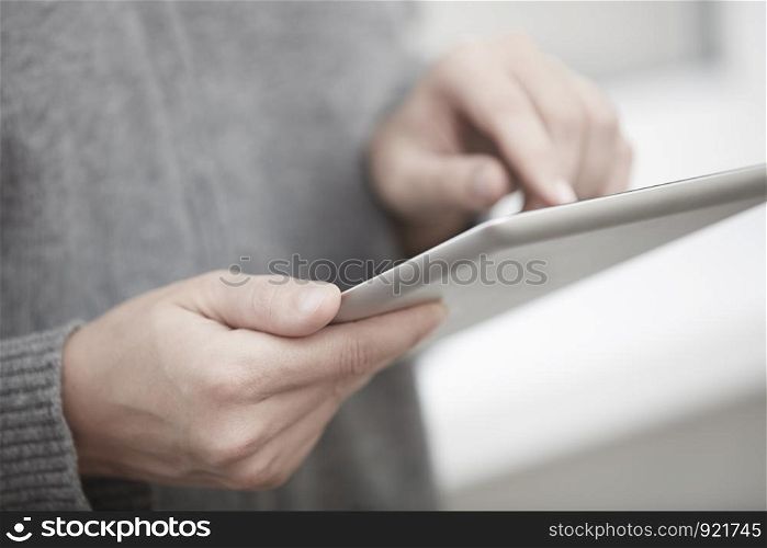 Woman with digital tablet surfing the web. Close-up view