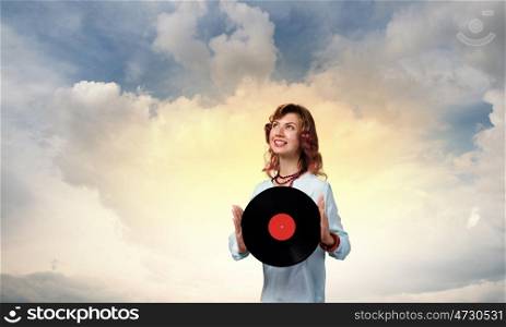 Woman with disco plate. Young woman in casual wearing headphones and holding disco plate