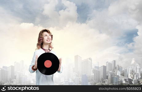 Woman with disco plate. Young woman in casual wearing headphones and holding disco plate