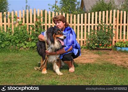 woman with dog near wooden fence