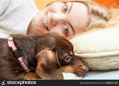 Woman with dog waking up in the morning after sleeping. Young girl laying in bed.. Woman with dog waking up in bed after sleeping.