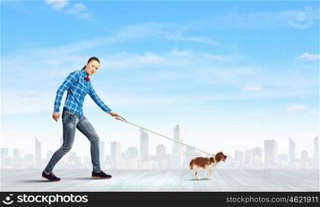 Woman with dog. Young woman in casual walking with dog on lead