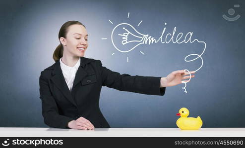 Woman with duck toy. Young businesswoman and yellow rubber duck toy on table