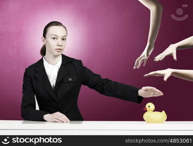 Woman with duck toy. Young businesswoman and yellow rubber duck toy on table