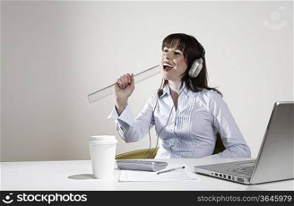 Woman with earphones fooling around at desk