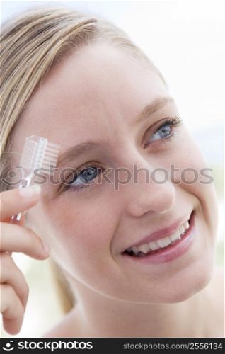 Woman with eyebrow brush smiling