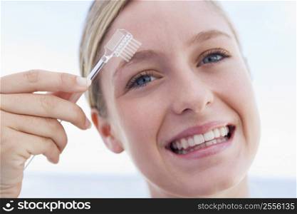 Woman with eyebrow brush smiling