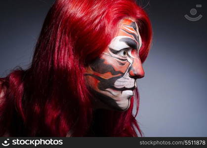 Woman with face painting in dark room