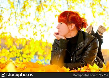 woman with fallen leaves on a sunny day