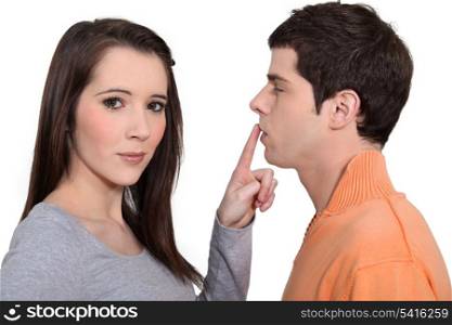 Woman with finger touching man&rsquo;s lips