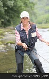 woman with fly fishing line in river