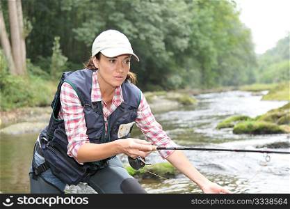 woman with fly fishing rod in river