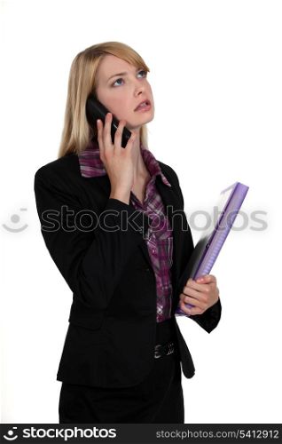 Woman with folder making telephone call