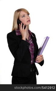 Woman with folder making telephone call