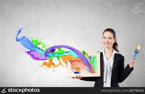 Woman with frame. Young woman holding wooden frame with colorful splashes