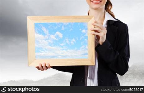 Woman with frame. Young woman holding wooden frame with colorful splashes
