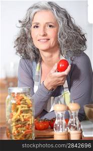 Woman with fresh tomatoes and a jar of pasta
