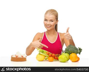 woman with fruits and cake pointing at healthy food