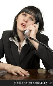 Woman with frustrated or irritated expression on office phone.
