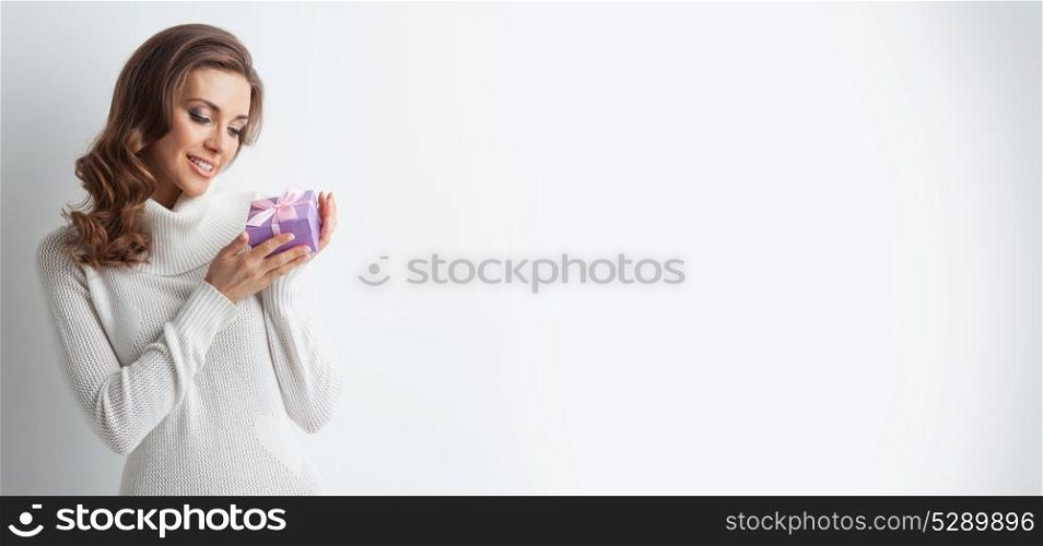 Woman with gift. Young woman in white sweater with gift box