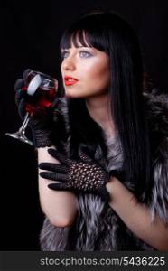 Woman with glass of red wine on black