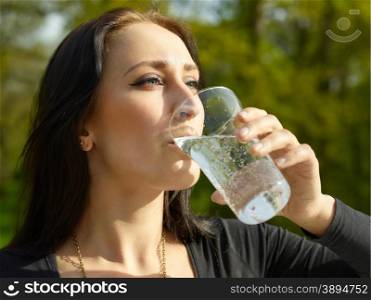 Woman with glass of sparkling water, sunny summer day