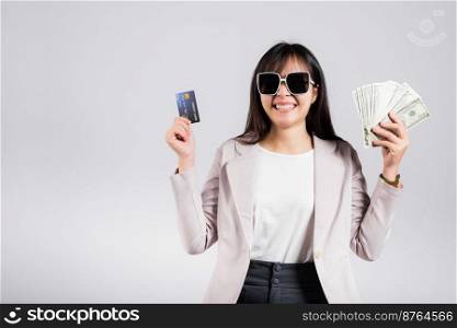 Woman with glasses confident smiling holding dollars money banknote and credit card for payment on hand, Portrait excited happy Asian young female show choose studio shot isolated on white background