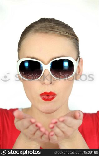 Woman with glasses pulling air kiss