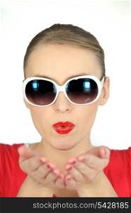 Woman with glasses pulling air kiss