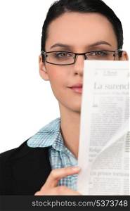 Woman with glasses reading a newspaper