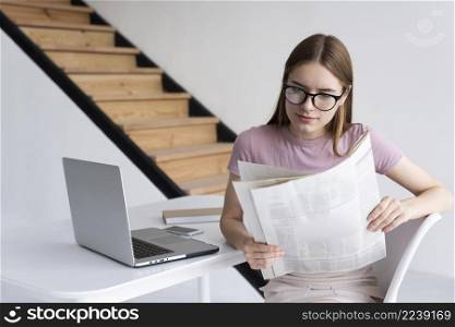 woman with glasses reading newspaper