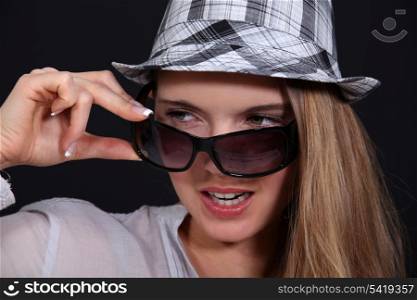Woman with glasses taking off her hat