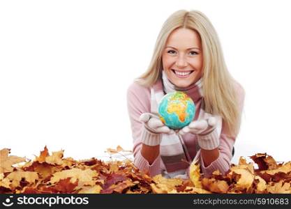 Woman with globe laying on dry autumn leaves isolated on white. Woman with globe
