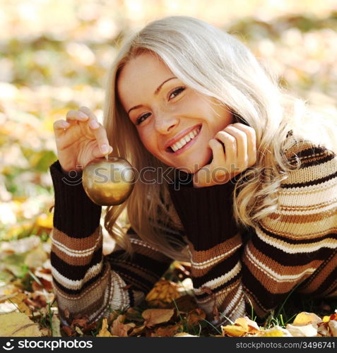 woman with golden apple in autumn park