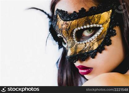 woman with golden venetian mask black hat white background