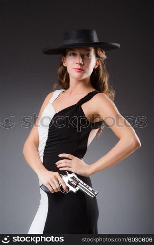 Woman with gun against dark background