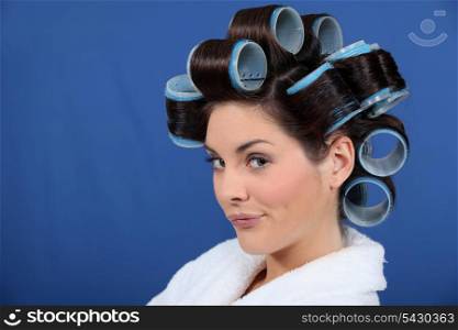 woman with hair curlers pouting