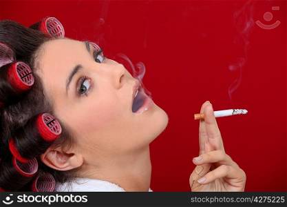 Woman with hair rollers smoking