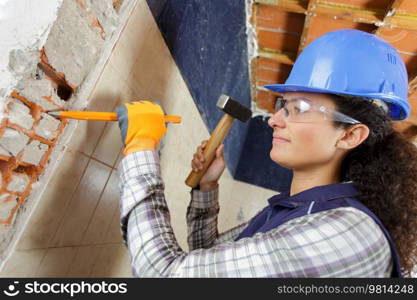 woman with hammer and chisel working in clients house