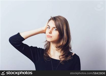 Woman with hand on head, straightens the hair