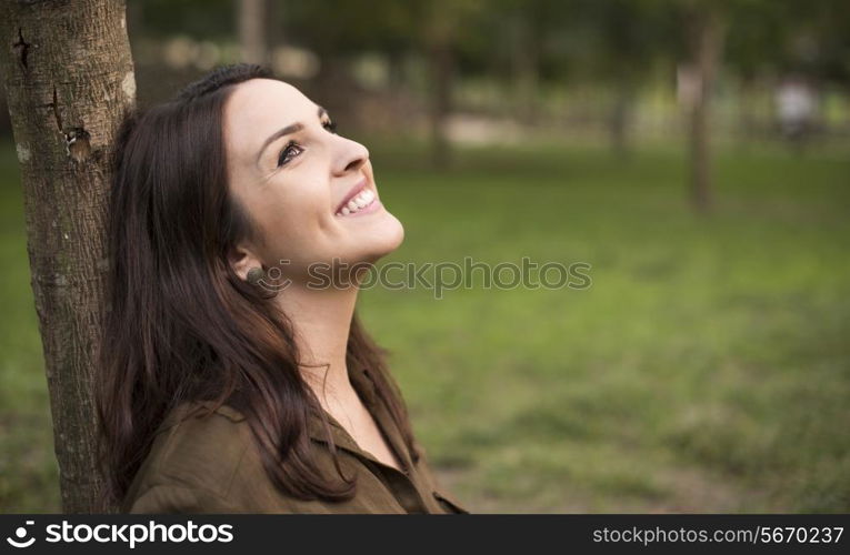 Woman with happy expression relaxing on meadow