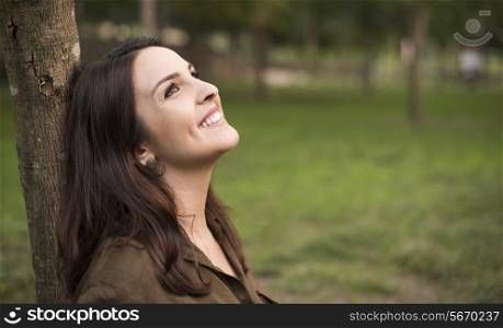 Woman with happy expression relaxing on meadow