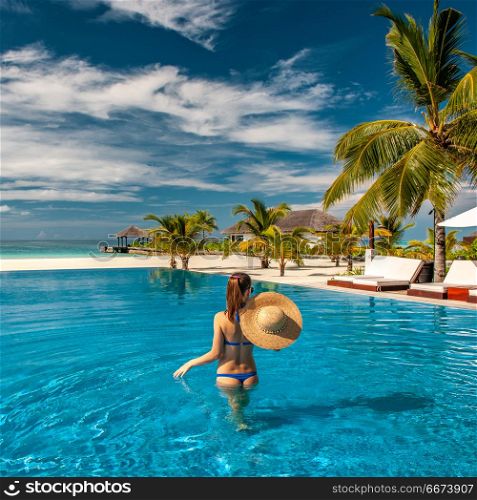 Woman with hat at beach pool in Maldives. Woman with sun hat at beach pool in Maldives