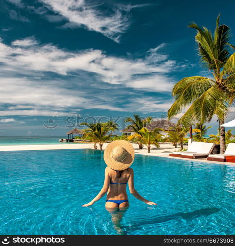 Woman with hat at beach pool in Maldives. Woman with sun hat at beach pool in Maldives