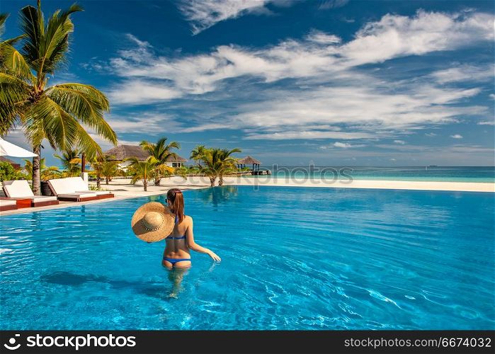 Woman with hat at beach pool in Maldives. Woman with sun hat at beach pool in Maldives