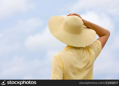Woman with hat in front of sky