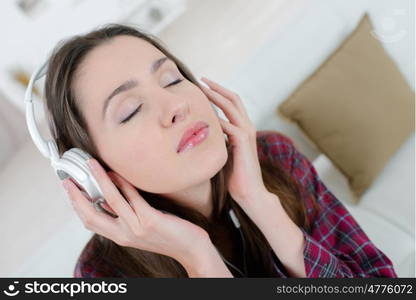 woman with headphone listening music standing at home