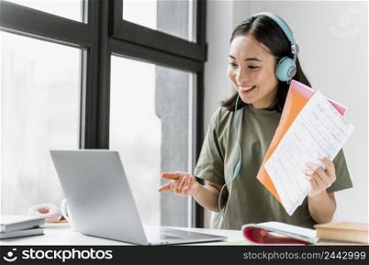 woman with headphones having video call laptop