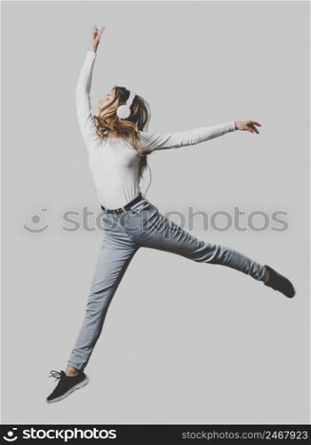woman with headphones jumping air